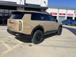 High angle side view of a 2027 Kia Telluride showing the lifted wheel arches and room for larger All Terrain tires.